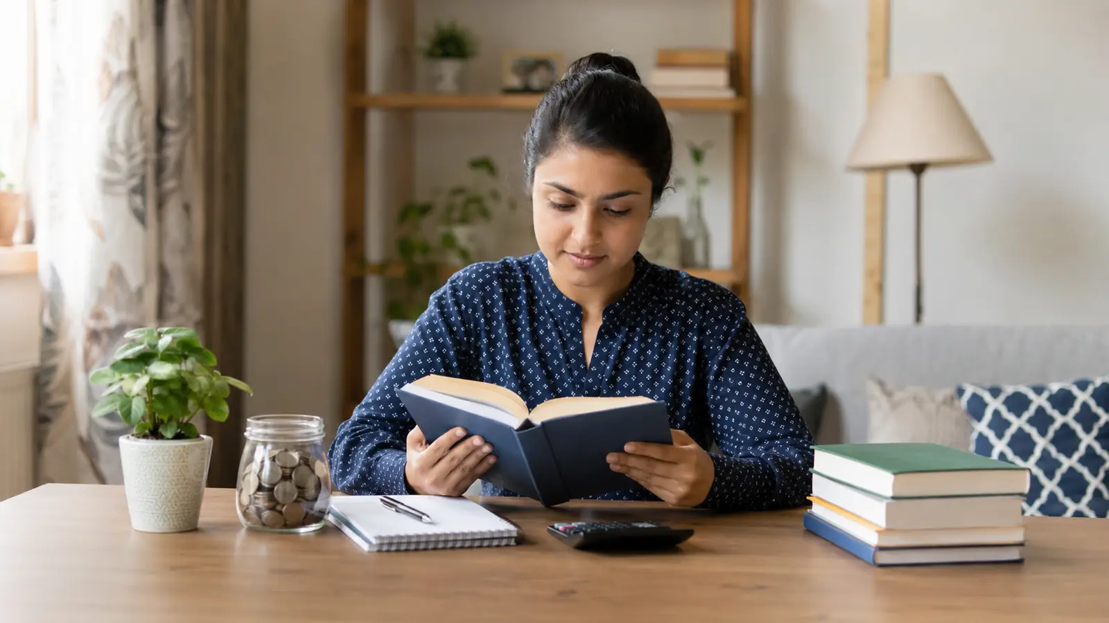 Indian beginner reading personal finance books and taking notes at home