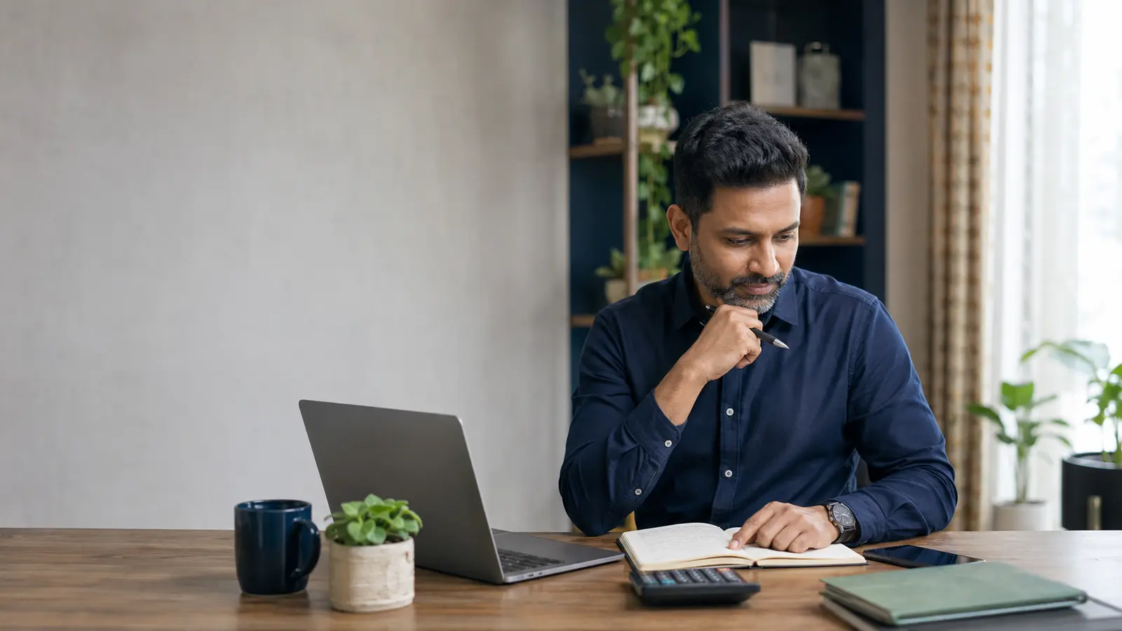 Mid-career Indian professional reviewing a long-term gratuity and retirement planning notebook at a desk